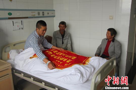 被救的李忠起、張總鳳夫婦看望受傷后的李運(yùn)飛?！⊥粲?攝