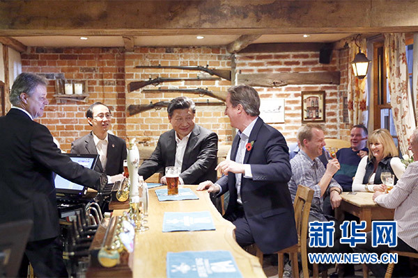 這是會(huì)晤結(jié)束后，習(xí)近平在卡梅倫陪同下乘車(chē)前往當(dāng)?shù)匦℃?zhèn)體驗(yàn)酒吧文化。新華社記者 鞠鵬 攝